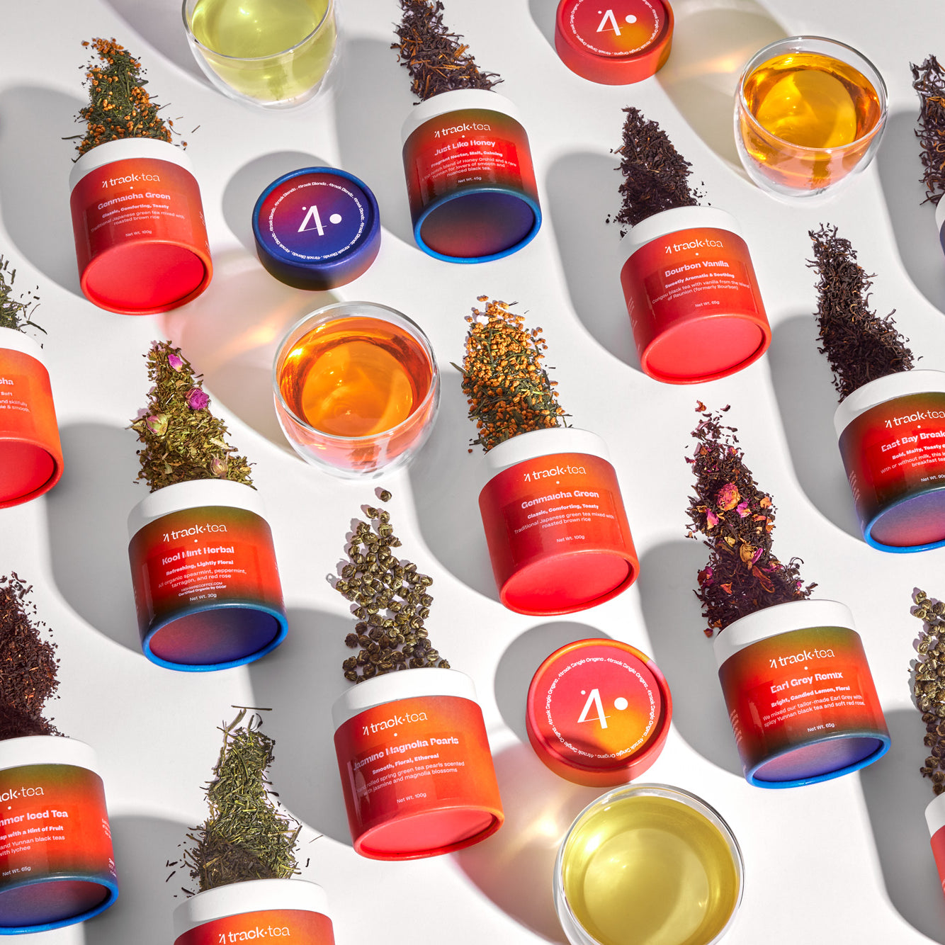 Multiple tubs of 4 Track Tea and glasses of brewed tea arranged artfully