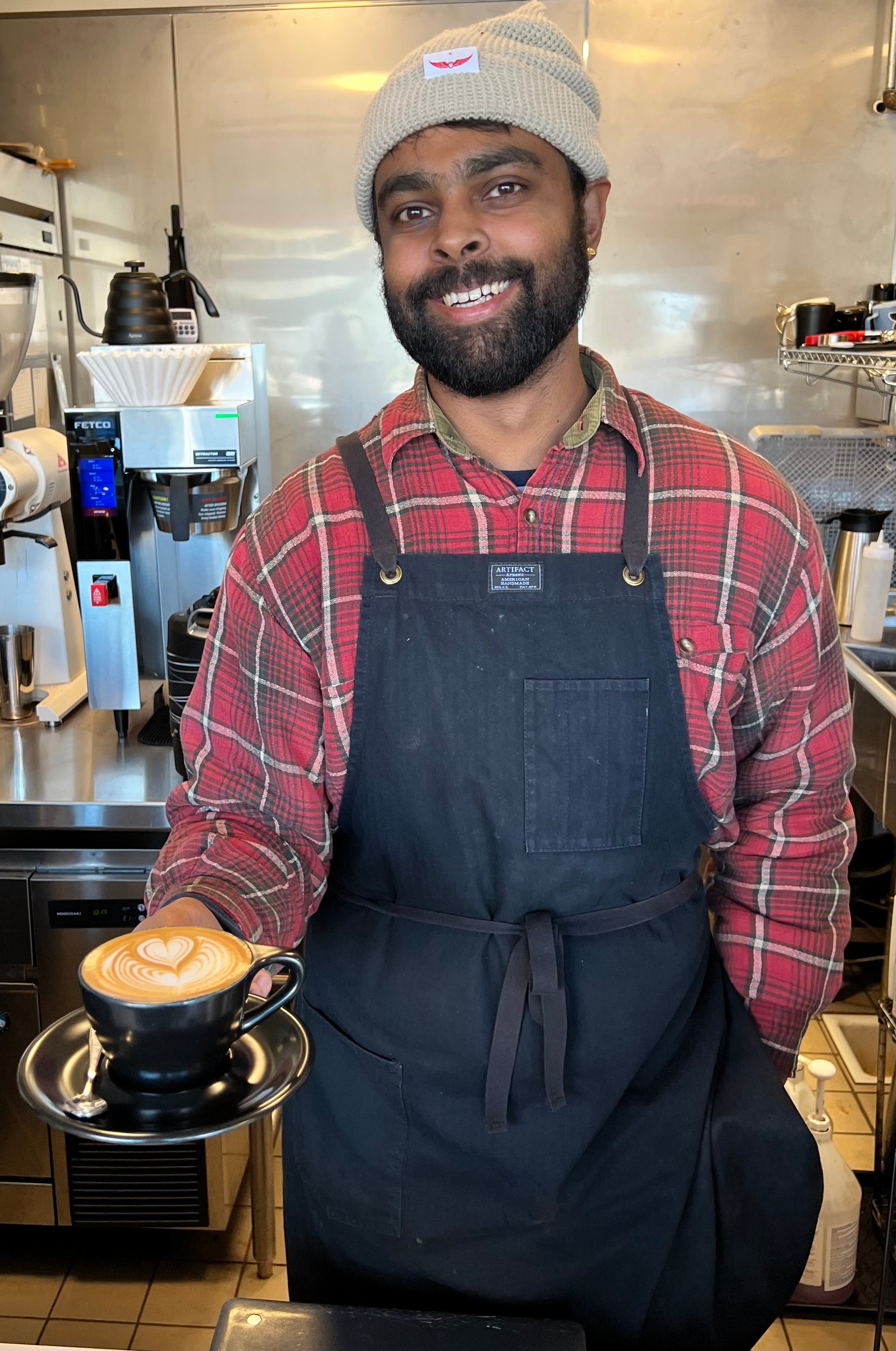 A Highwire employee holding a cup of coffee