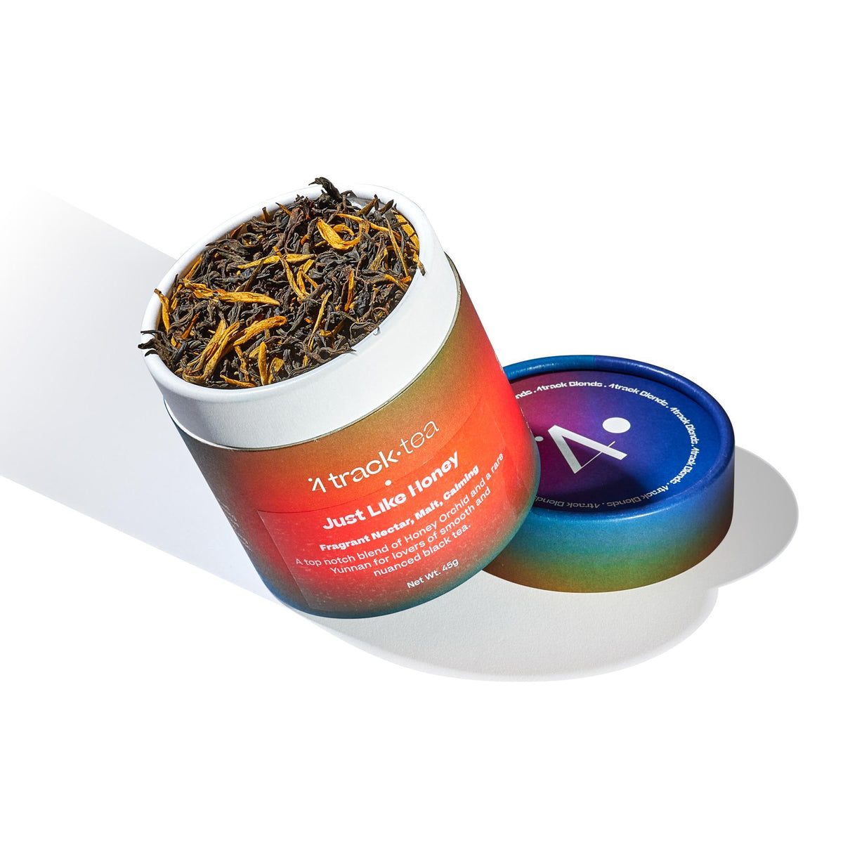 A container of Chinese Black Tea leaves with a colorful label, opened to display the dark, leafy tea inside.